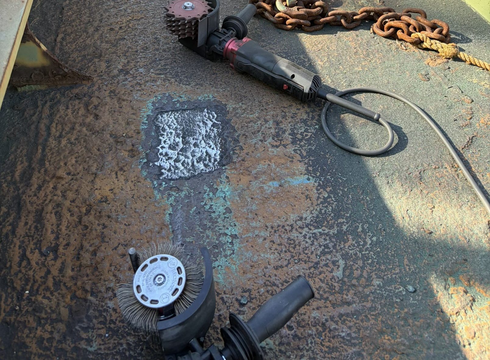Area of a shipyard deck stripped to steel with the disc
